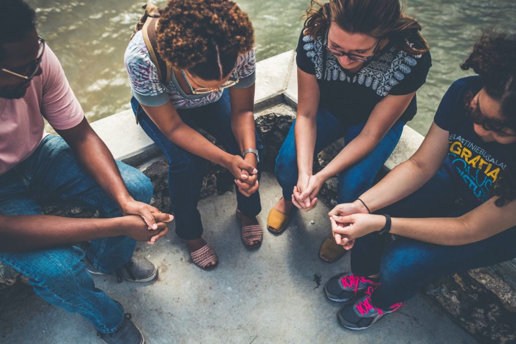 Missionaries and students praying together